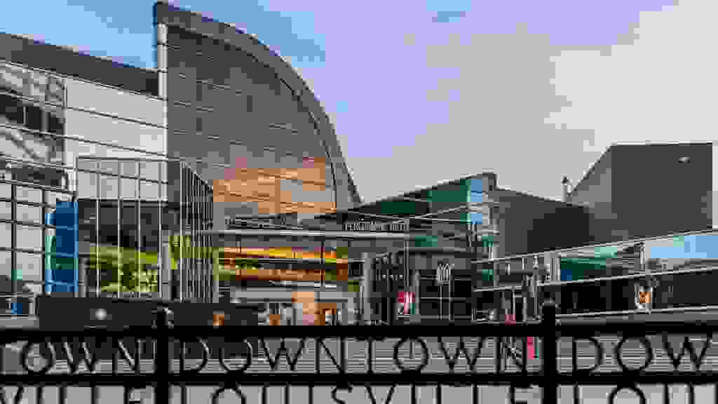 Louisville, Kentucky, USA - March 27th 2016: Kentucky Center for the Performing Arts building in Louisville Kentucky with rod iron fence which states 'Downtown Louisville' in foreground.