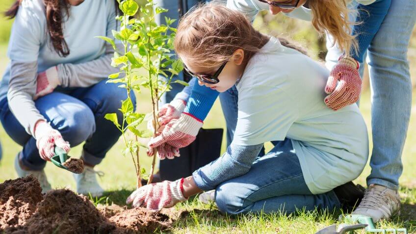 young child gardening with other people