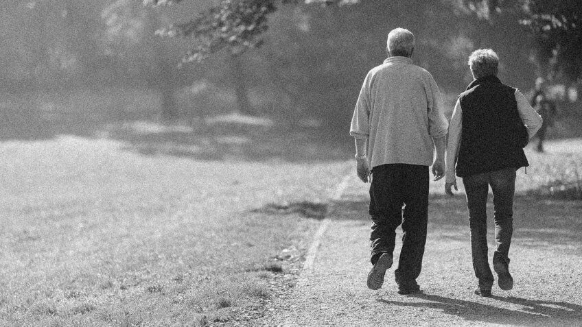 happy retired couple on a walk together in the park