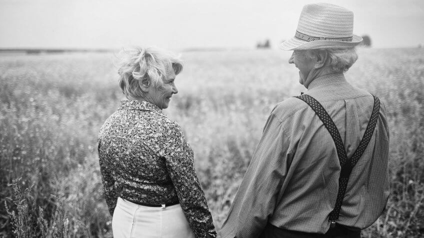 retired couple on a walk in a field