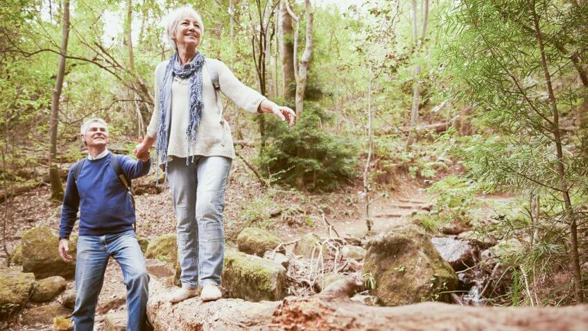 elderly couple walking in the woods