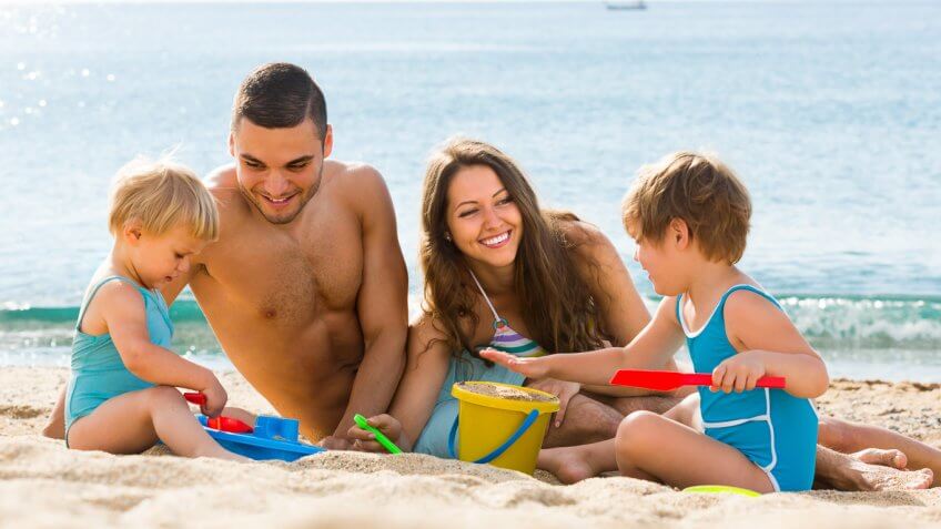 family relaxing and playing at the beach
