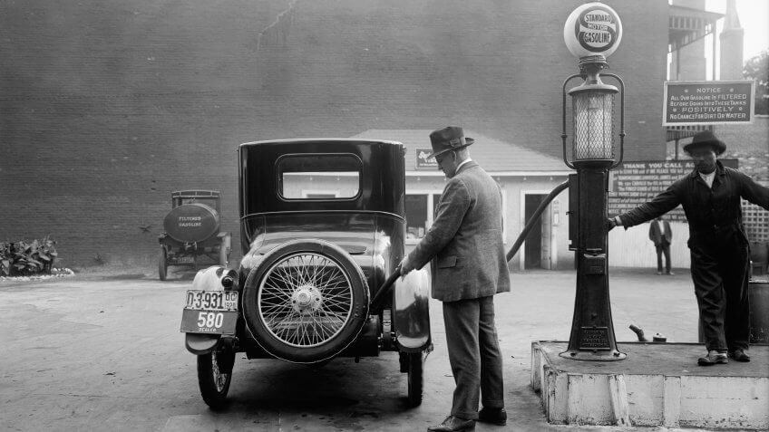 Man fueling his car at a self-service Standard Motor gas station, What $100 Was Worth in the Decade You Were Born