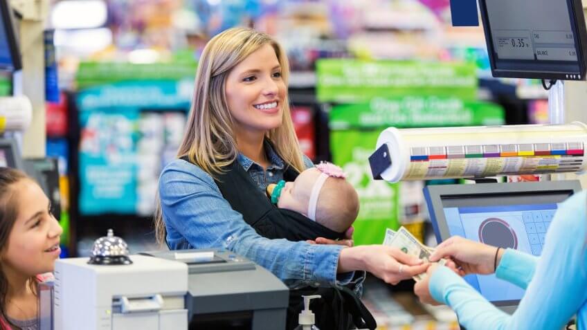 Mid adult Caucasian woman is smiling while shopping in grocery store.