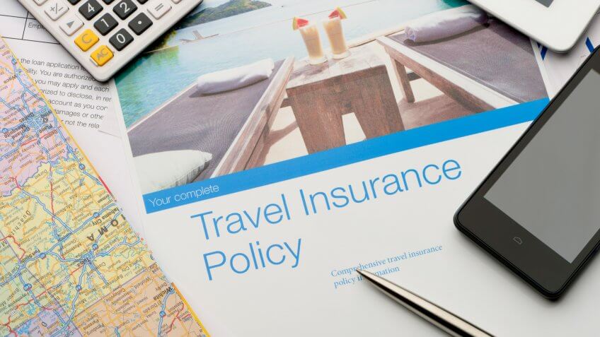 Travel insurance policy document with paperwork and technology.