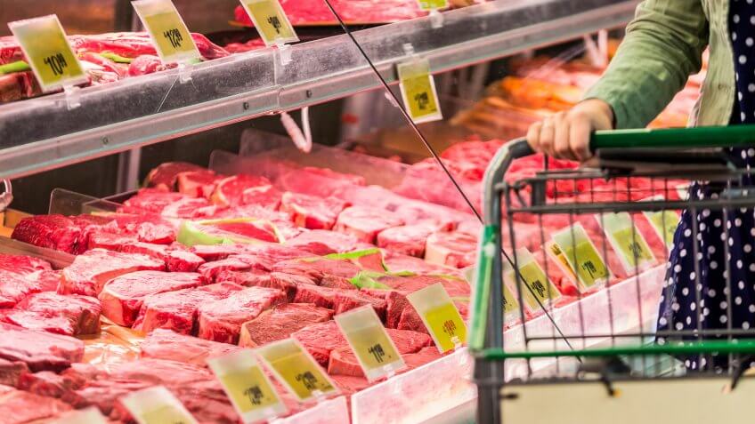 Woman shopping for raw red meat.