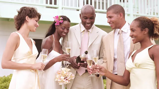 20 Items You Will Regret Buying This Summer, 20-24 years, 25-29 years, 30-34 years, Adults Only, Best Man, Bottle, Bouquet, Bride, Bridegroom, Bridesmaid, Celebratory Toast, Champagne Flute, Females, Five People, Formalwear, Group Of People, Males, Necktie, Newlywed, Part Of A Series, Pouring, Suit, Summer, Wedding, Wedding Dress, Young Couple, Young Men, Young Women, balcony, boyfriend, celebration, champagne, color image, day, drinking, girlfriend, heterosexual couple, holding, horizontal, house, husband, joy, mid adult men, outdoors, people, photography, smiling, wife