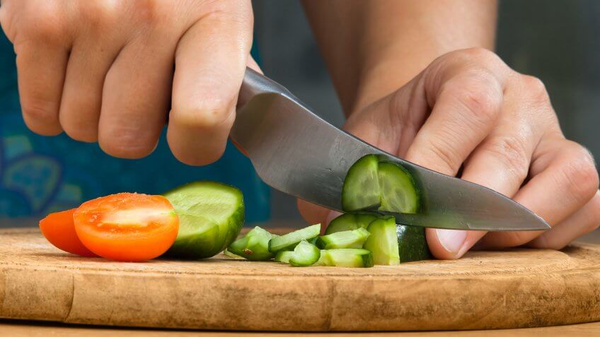 10 Items You Should Never Get at the Dollar Store, Activity, Adult, Adults Only, Chef, Chopping, Close-up, Cooking, Cross Section, Cucumber, Cutting, Domestic Kitchen, Domestic Room, Eating, Females, Food, Green Color, Healthy Eating, Healthy Lifestyle, Human Body Part, Human Finger, Human Hand, Kitchen, Kitchen Knife, Lunch, Motion, One Person, One Woman Only, Only Women, Organic, Part Of, Plank, Preparing Food, Salad, Slice, Table, Tomato, Vegetable, Vegetarian Food, Wood - Material, freshness, horizontal, indoors, people, photography, preparation, red, women