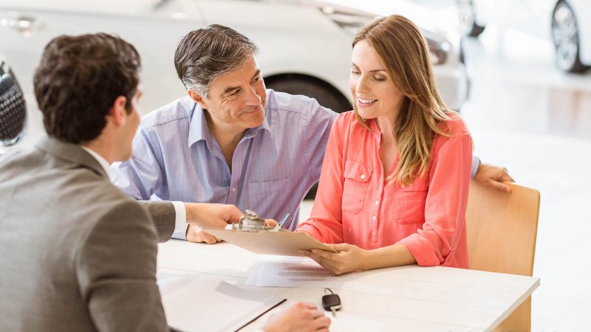 couple looking over documentation while speaking with a salesperson