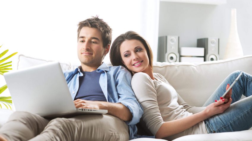 couple looking at a laptop while sitting on the couch