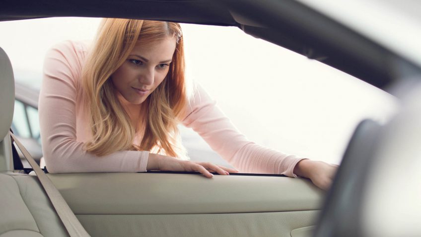woman inspecting a car's interior
