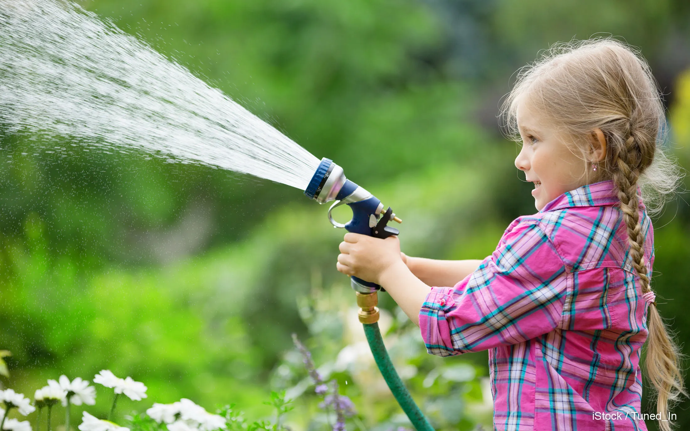 Water the flowers. Поливает из шланга. Девушка поливает из шланга. Вода из шланга. Поливание цветов детей в саду.