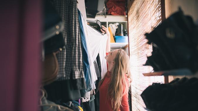 girl searching for clothes in her messy closet