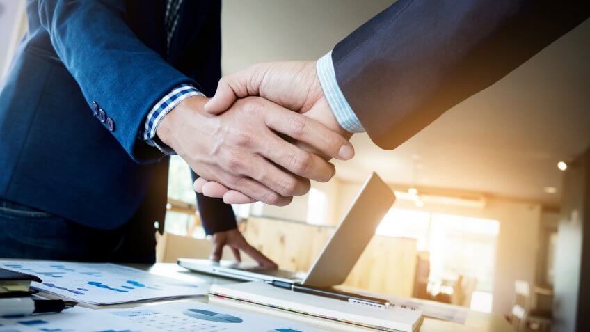 Biggest Money Scams of All Time, Two confident business man shaking hands during a meeting in the, dealing, greeting and partner concept., success