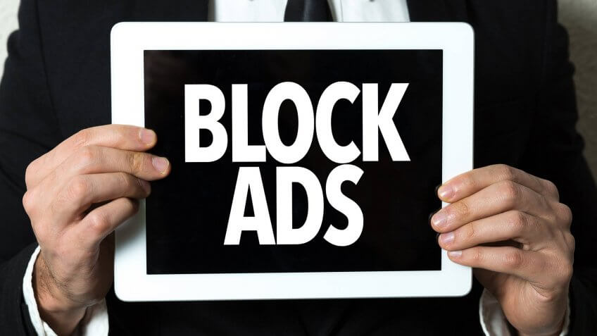 Business man holding a tablet with the text: Block Ads.