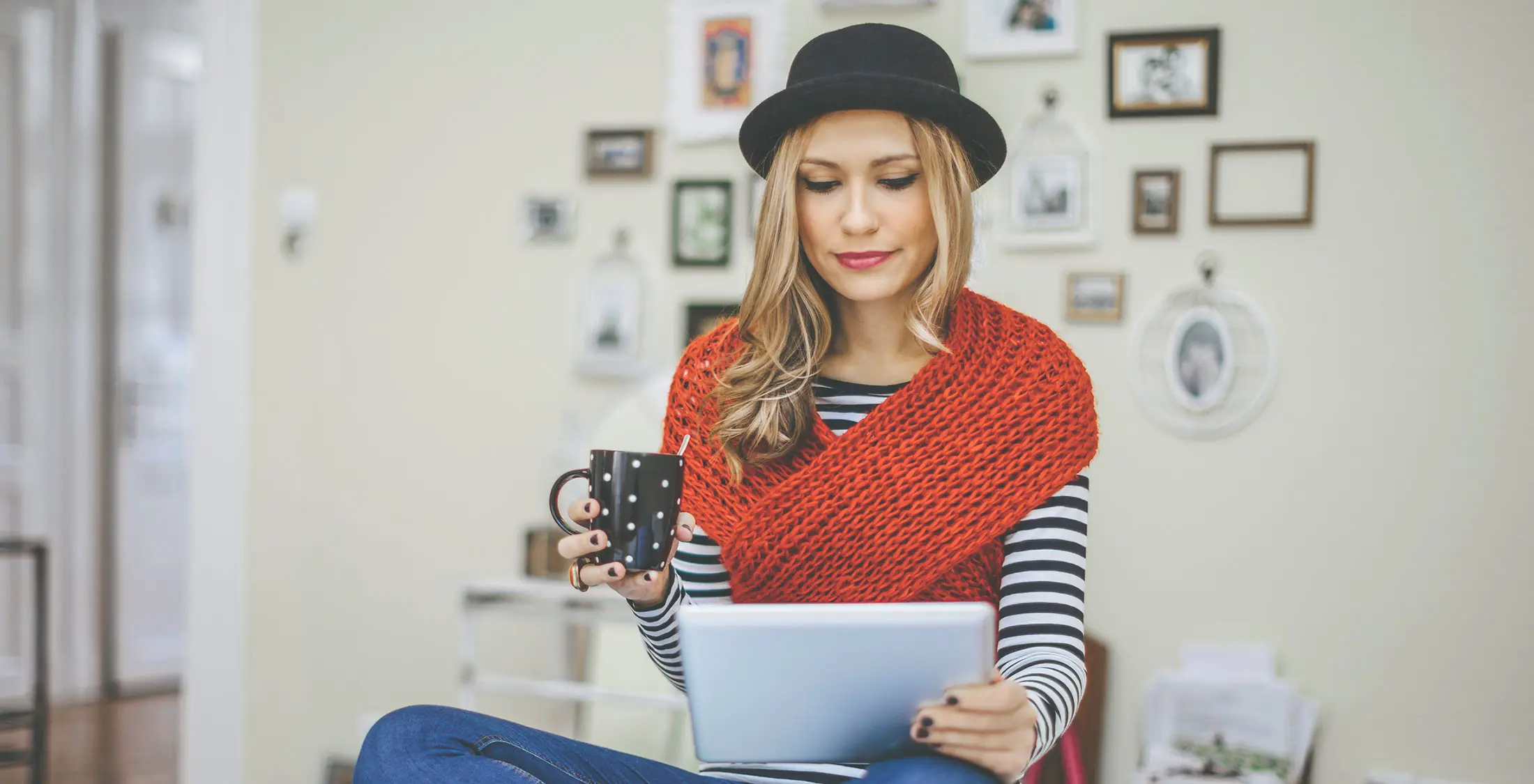 girl looking at tablet drinking coffee