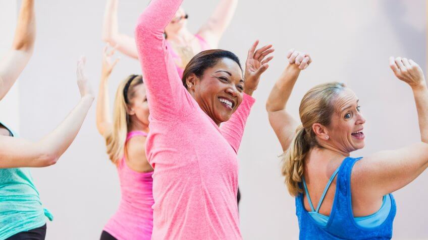 A multi-ethnic group of women having fun taking an exercise class.