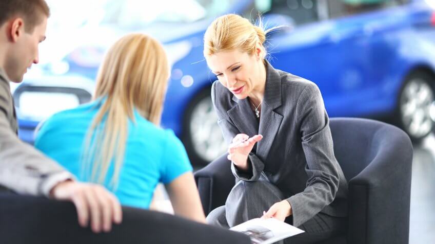 Young to middle aged couple buying new car.
