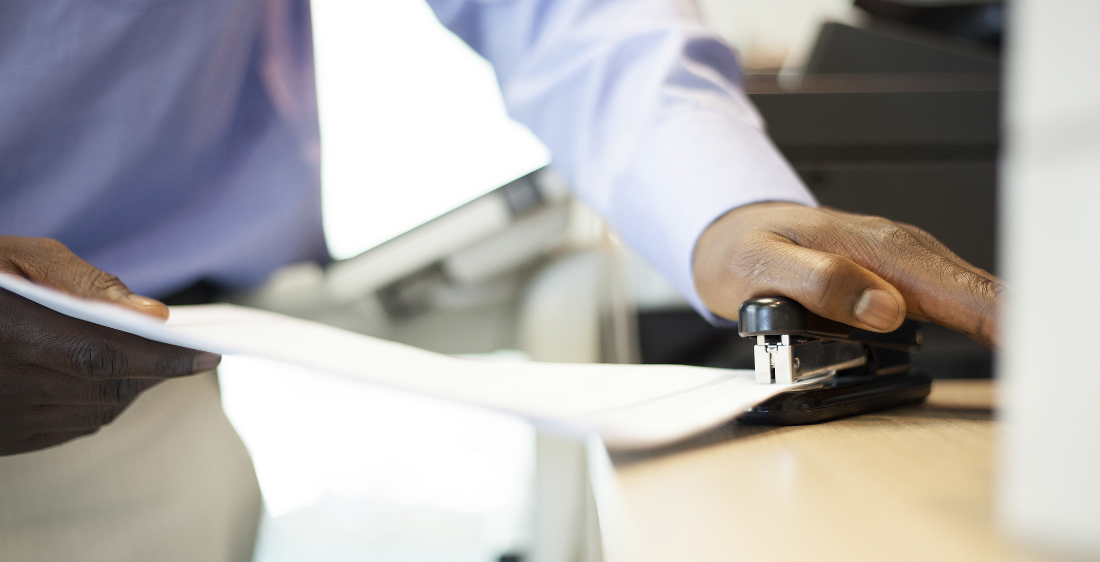 Buying used office supplies. man using stapler