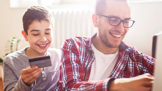 father and son shopping online with a credit card