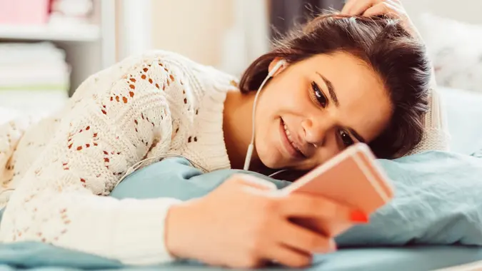 Smiling girl in bed texting