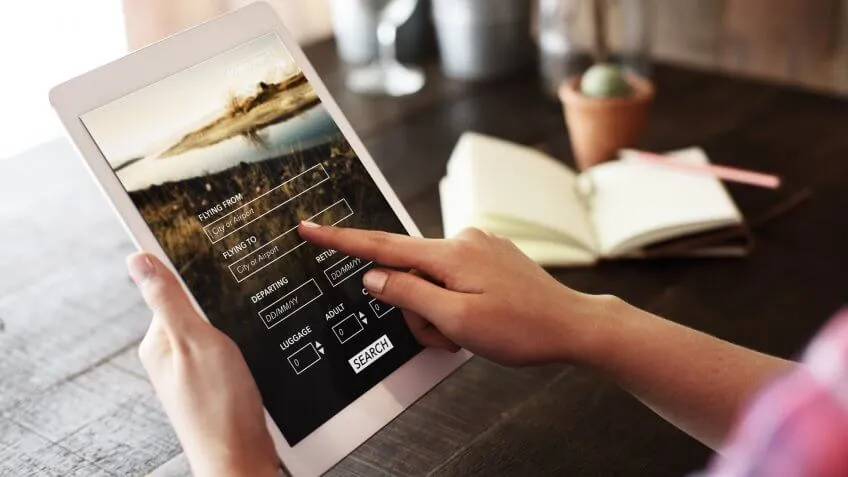 woman looking up flights on her ipad tablet