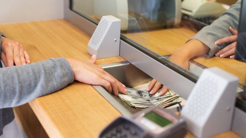 11902, Horizontal, woman depositing USD money into bank