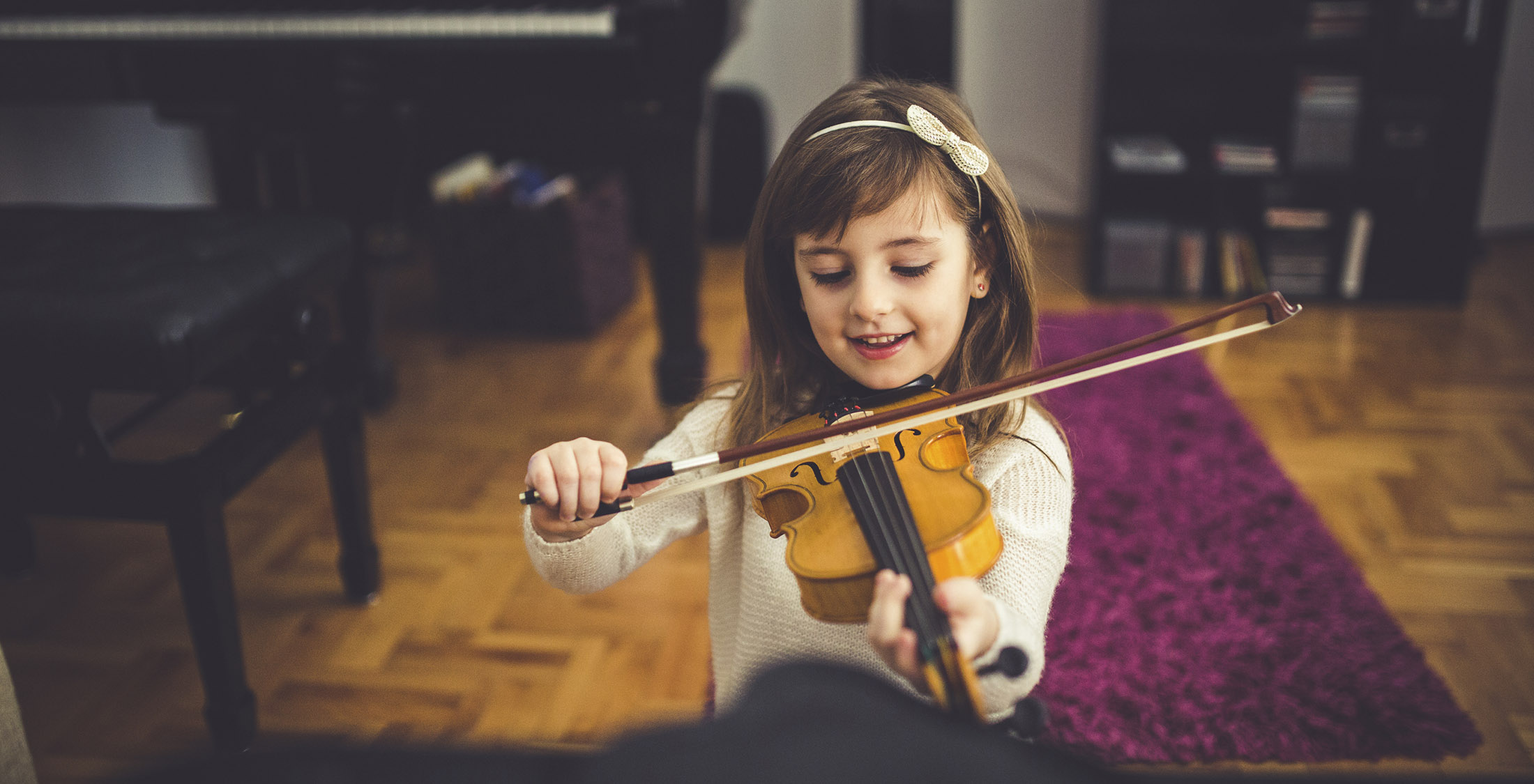 Buy used musical equipment. Young girl playing violin at home