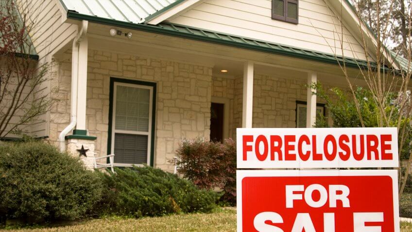 Foreclosure for sale sign on the lawn in front of a home