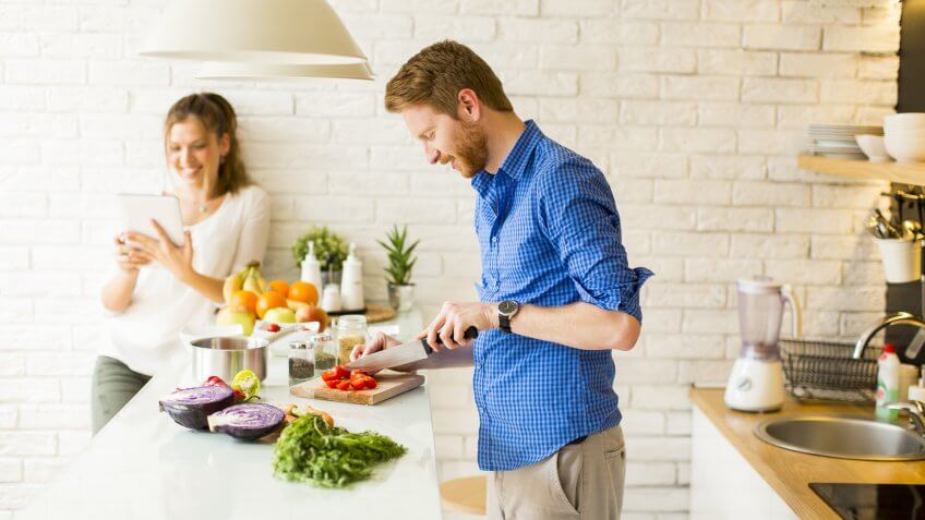 Man cutting produce, making dinner.