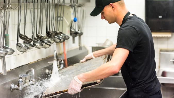 young dishwasher working at a restaurant kitchen.
