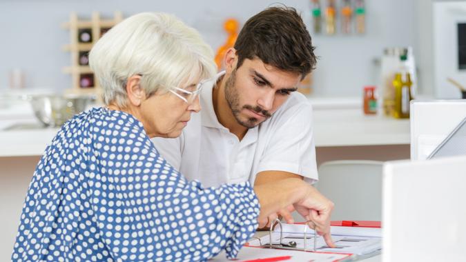 son helping his mother with some document.