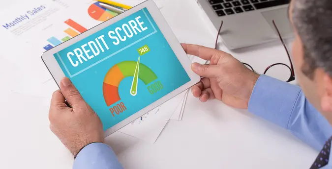 man looks at good credit score on tablet