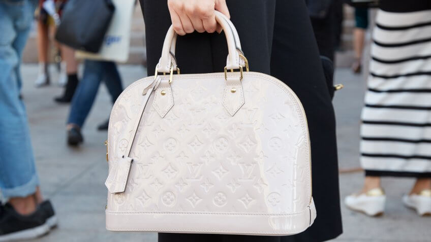 MILAN - SEPTEMBER 22: Woman with white Louis Vuitton bag before Cristiano Burani fashion show, Milan Fashion Week street style on September 22, 2016 in Milan.