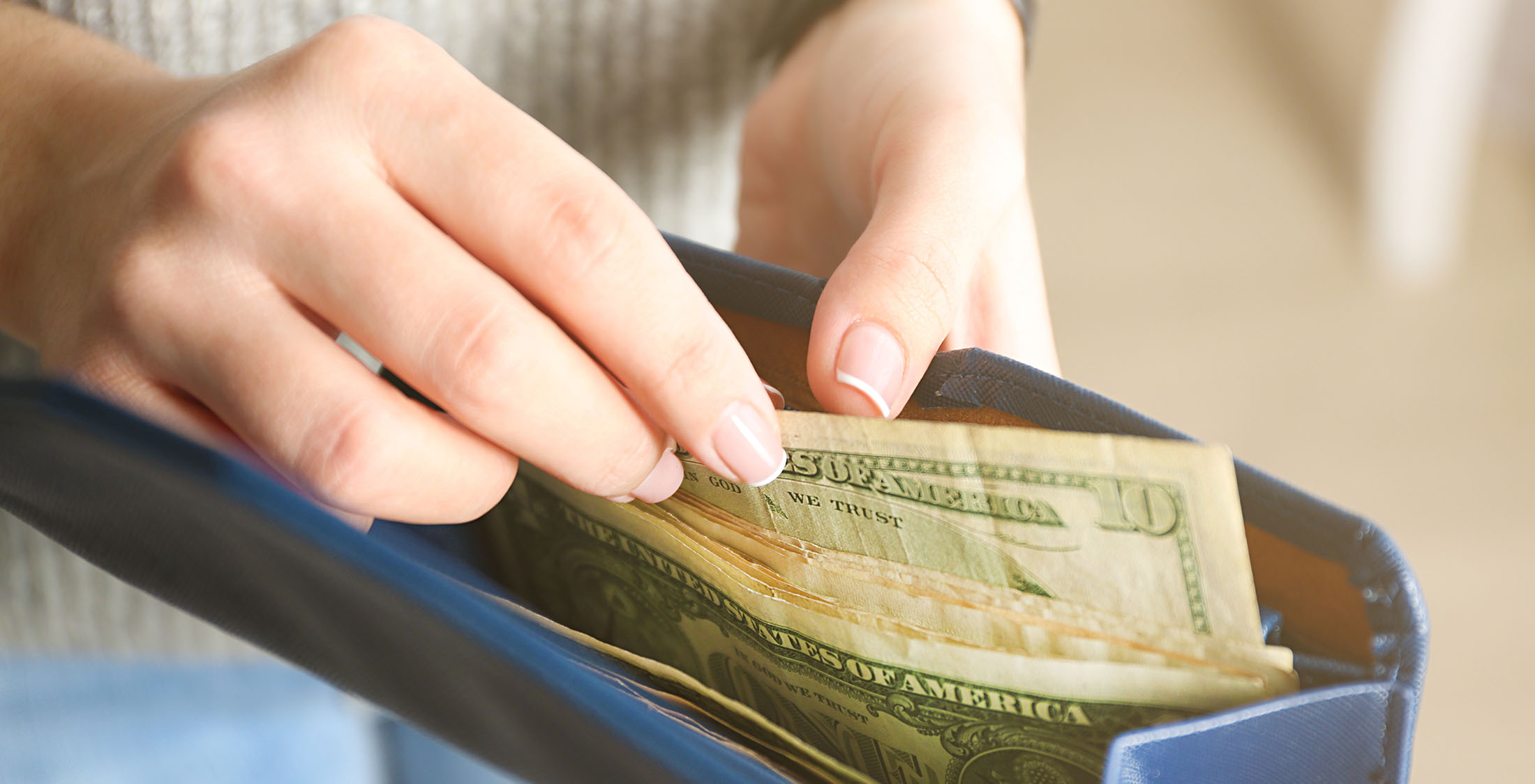 You spend and don't budget. woman pulling money from clutch purse
