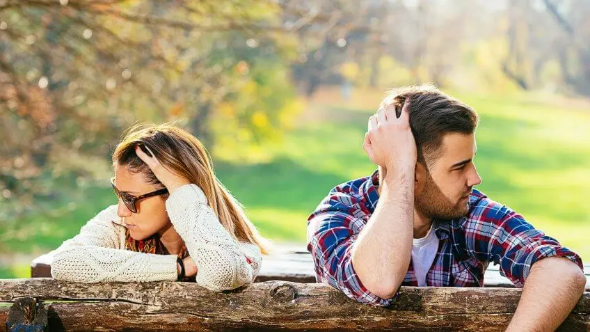 man and woman outside looking away from each other