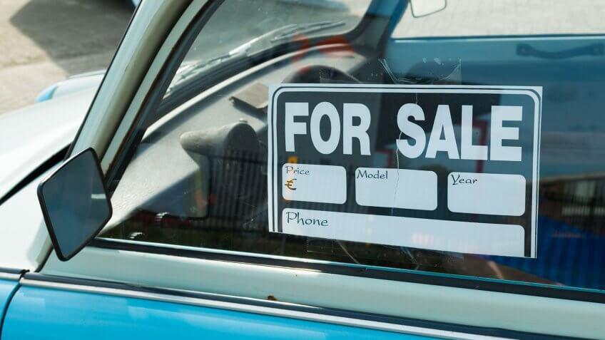 car with for sale sign in window