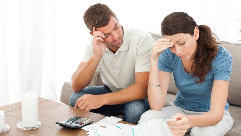 man and woman looking frustrated at documents