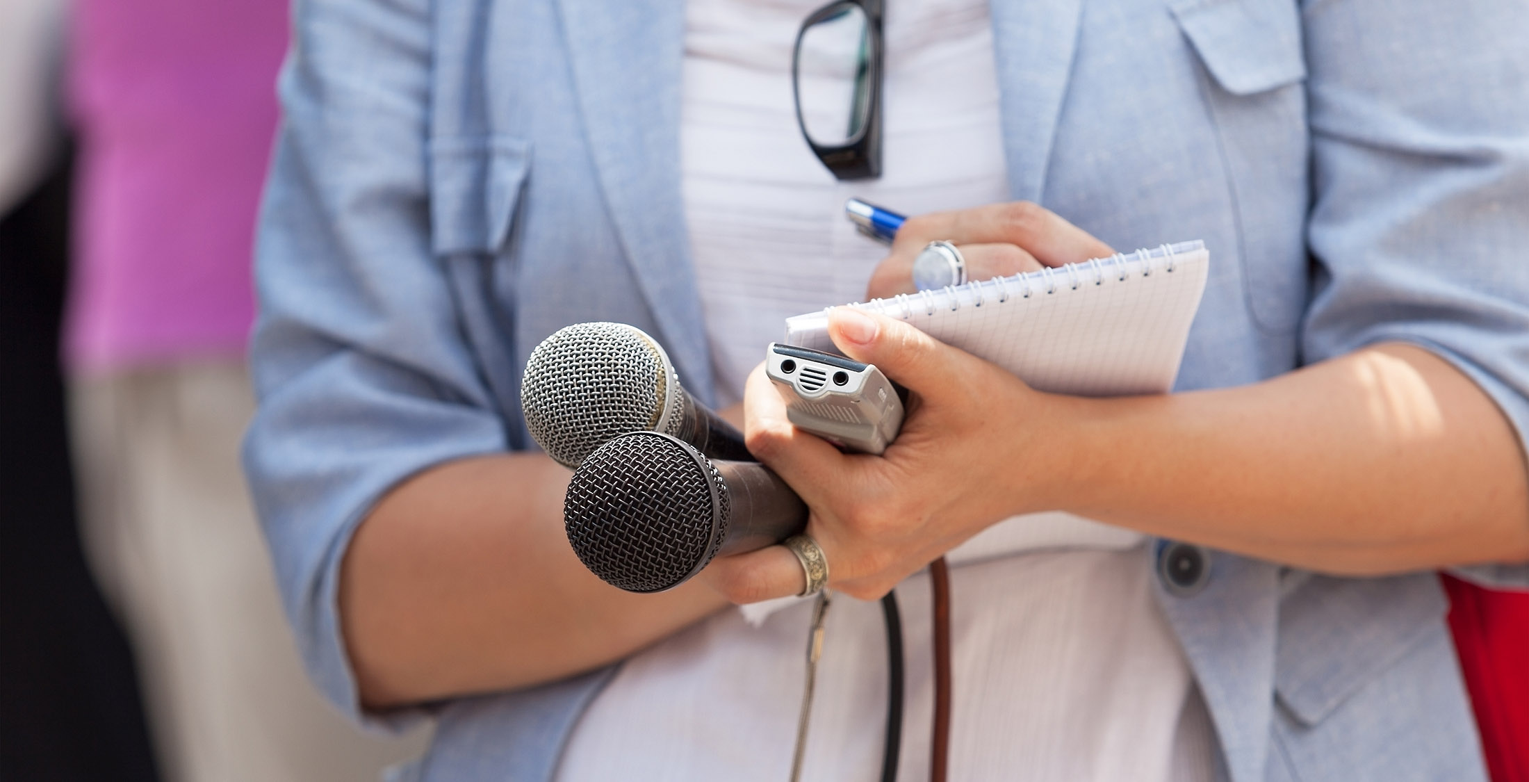 Check your business' public records. person writing in notepad and holding microphones
