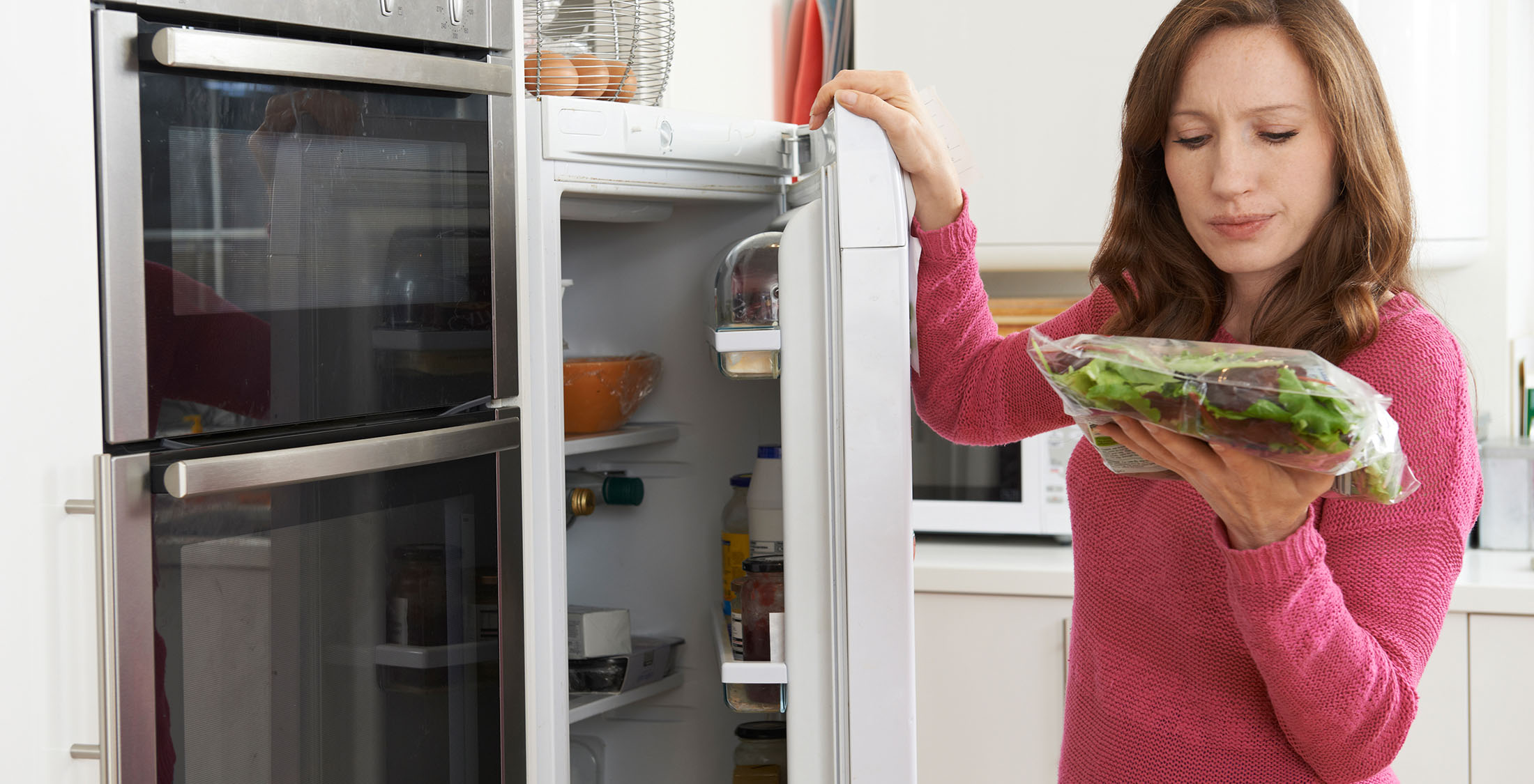 Stop throwing away food. woman looking at rotten veggies