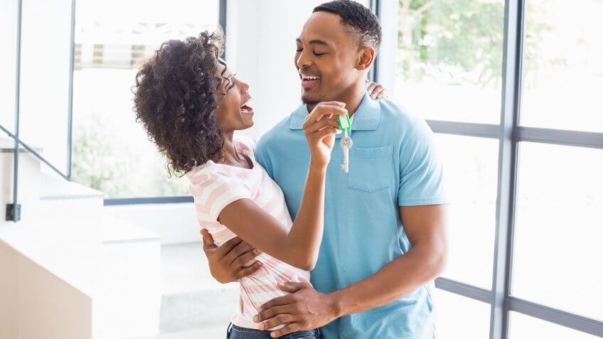 couple hugging holding keys