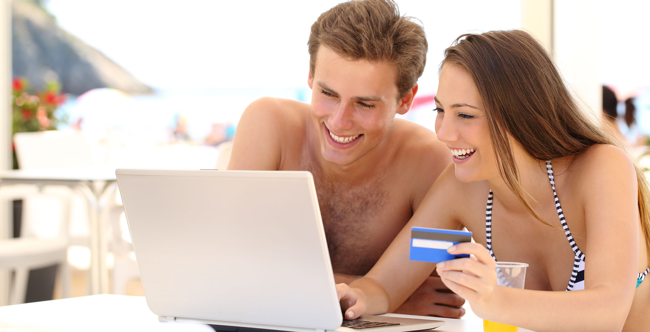 Use a rewards credit card for travel. man and woman with credit card using laptop