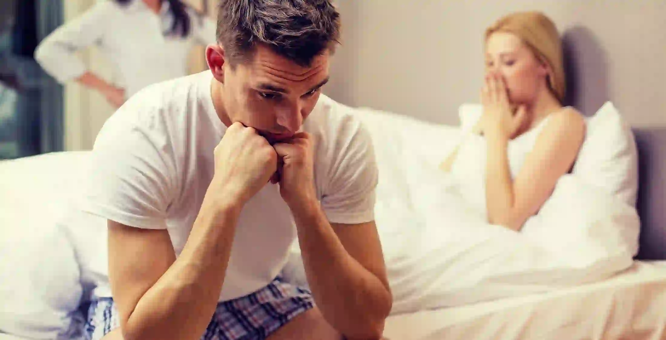 couple in bed looking concerned
