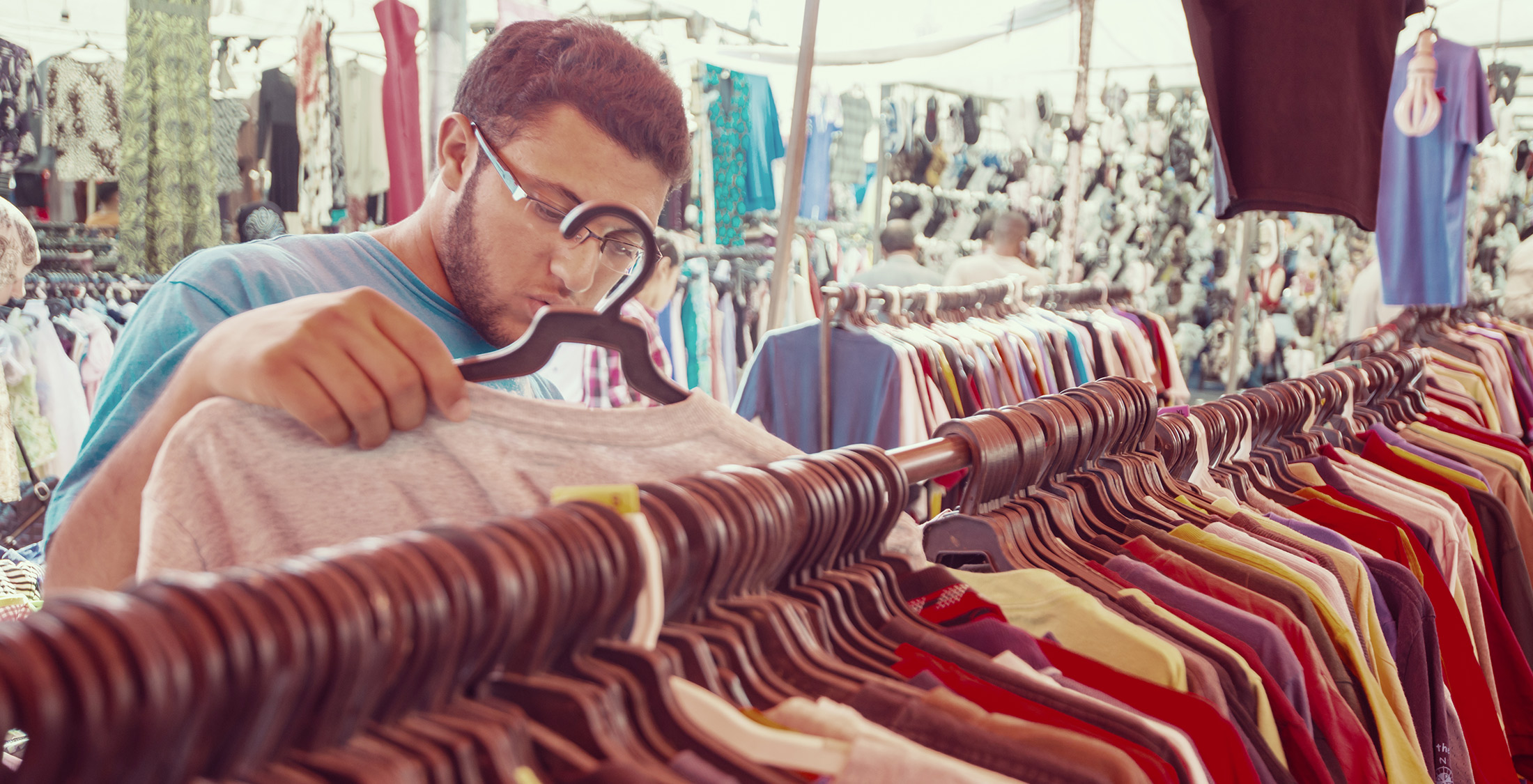 Compromise. man at store looking through a rack of shirts