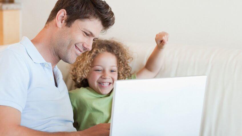 father and child looking at computer together