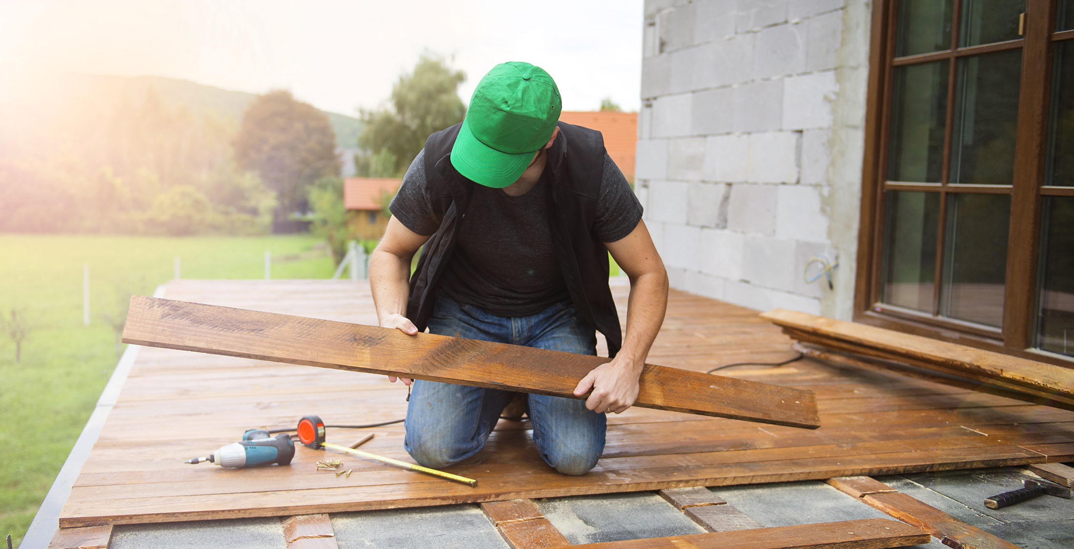 Renovate your outdoor space man installing new floor board on patio
