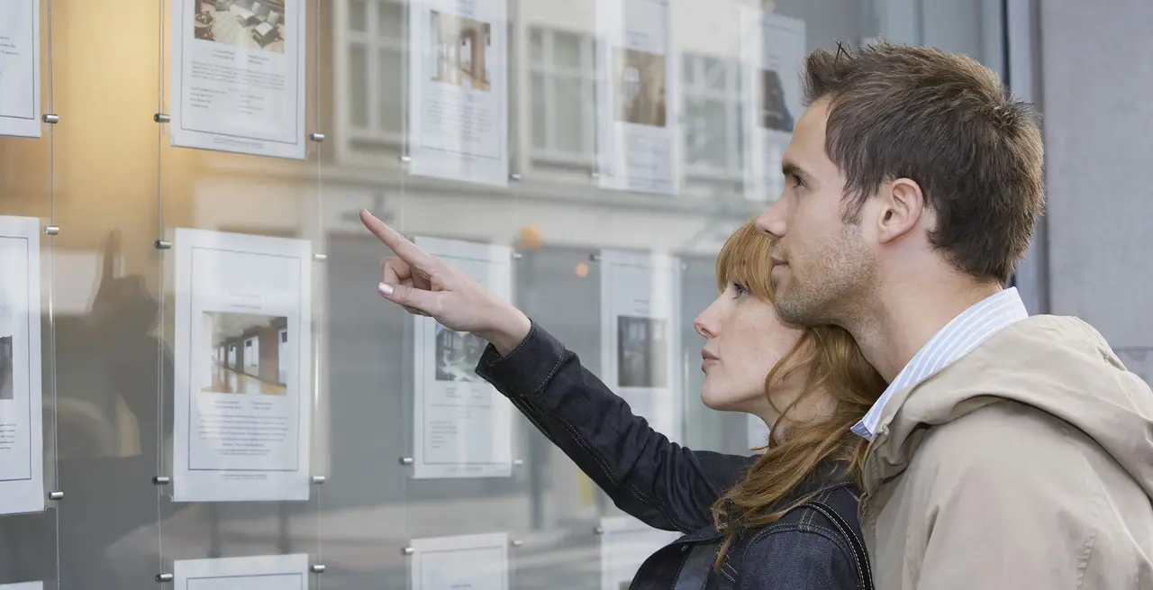 woman pointing out a picture pinned to bulletin board 