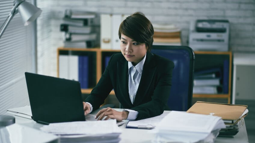 Young pretty lawyer searching information in laptop.