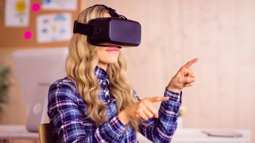Woman wearing Oculus VR goggles and pointing in air