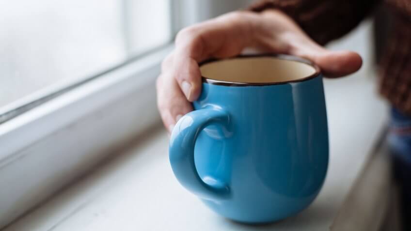 hand grabbing coffee mug